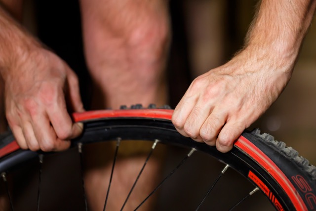 man repairing the tire of-a bicycle